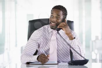 Royalty Free Photo of a Businessman at His Desk Talking on the Phone