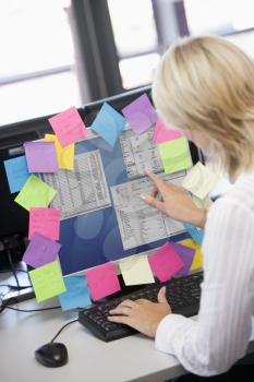 Royalty Free Photo of a Woman at a Computer Terminal Covered in Notes