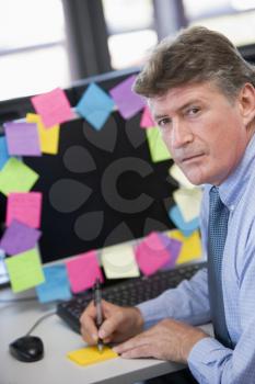 Royalty Free Photo of a Man With Notes on His Computer