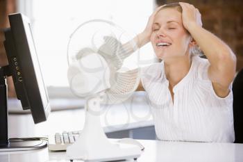 Royalty Free Photo of a Woman Cooling Off at a Fan