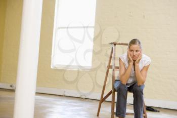 Royalty Free Photo of a Girl in an Empty Room Looking Bored