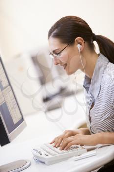 Royalty Free Photo of a Woman at a Computer Listening to Music