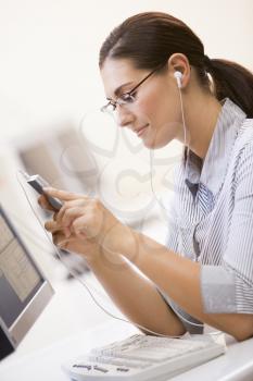 Royalty Free Photo of a Woman at a Computer Listening to Music