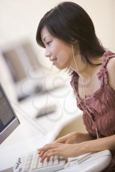 Royalty Free Photo of a Woman Listening to Music at a Computer