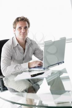Royalty Free Photo of a Man at a Desk With a Laptop