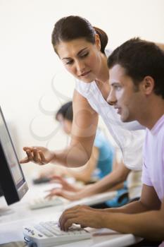 Royalty Free Photo of a Woman Helping a Man at a Computer