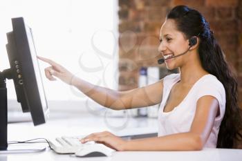 Royalty Free Photo of a Woman at a Computer Wearing a Headset