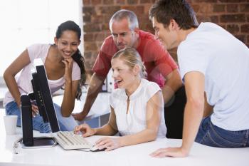 Royalty Free Photo of Four People Looking at a Computer