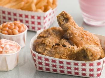 Royalty Free Photo of Southern Fried Chicken Coleslaw Baked Beans Fries and Strawberry Milkshake