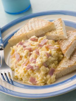 Royalty Free Photo of Cheesy Scrambled Egg With Ham and Toasted Triangles