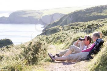 Royalty Free Photo of a Couple on a Cliff With Binoculars