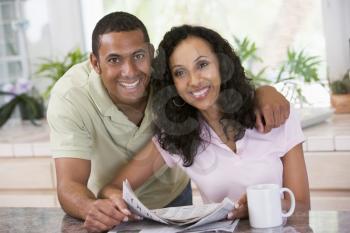 Royalty Free Photo of a Couple With a Paper and Coffee