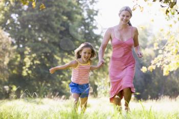 Royalty Free Photo of a Mother and Daughter Running in the Park