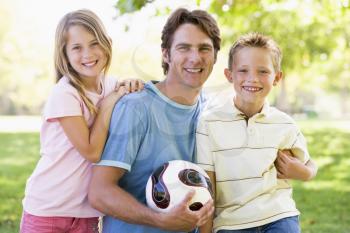 Royalty Free Photo of a Father and Children With a Ball