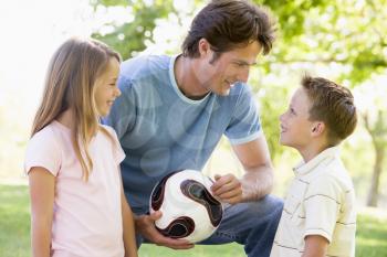 Royalty Free Photo of a Man and Two Children With a Ball