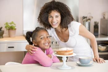 Royalty Free Photo of a Mother and Daughter With Cake and a Coffee