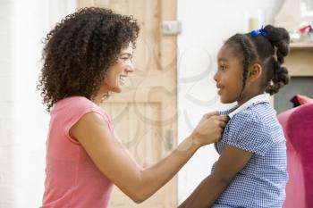 Royalty Free Photo of a Woman Buttoning Her Daughter's Top