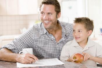 Royalty Free Photo of a Man and Boy With a Newspaper