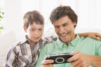 Royalty Free Photo of a Father and Son With a Game Controller