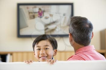 Royalty Free Photo of a Man and Boy Watching Television
