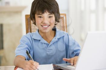 Royalty Free Photo of a Child Doing Homework With a Laptop