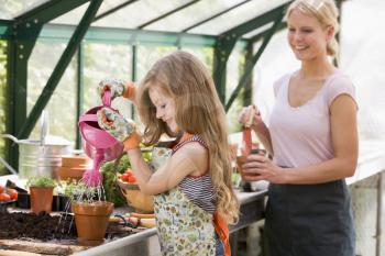 Royalty Free Photo of a Young Girl and Woman in a Greenhouse