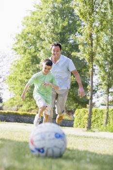 Royalty Free Photo of a Man and a Boy Playing Soccer