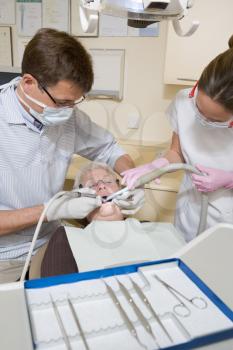 Royalty Free Photo of a Dentist and Assistant With a Patient