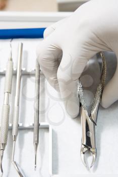 Royalty Free Photo of a Plastic Gloved Hand Reaching for Dental Tools