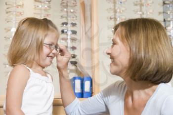 Royalty Free Photo of a Woman Helping a Girl Try on Glasses
