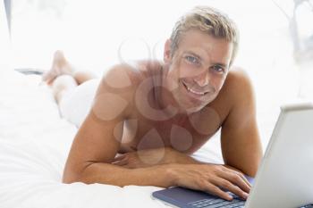 Royalty Free Photo of a Man Lying in Bed With a Laptop