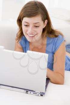 Royalty Free Photo of a Woman Lying on a Couch With a Laptop