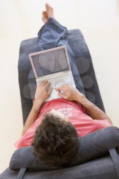 Royalty Free Photo of a Man in a Chair With a Laptop