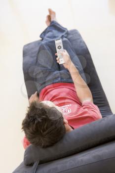 Royalty Free Photo of a Man in a Chair With a Remote Control