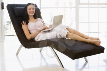 Royalty Free Photo of a Woman on a Chair With a Laptop