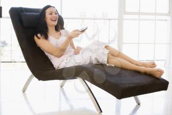 Royalty Free Photo of a Woman in a Chair With a Remote