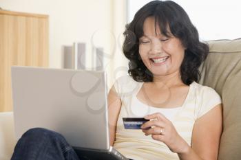 Royalty Free Photo of a Woman Using a Laptop and Holding a Credit Card