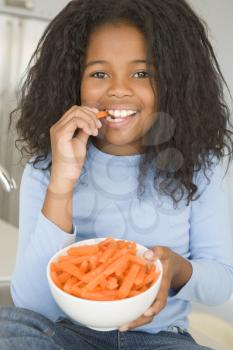 Royalty Free Photo of a Girl Eating Carrot Sticks