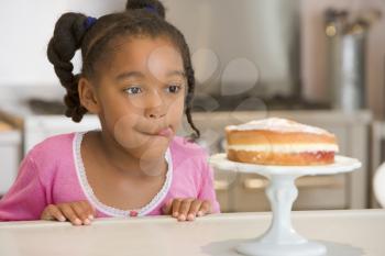 Royalty Free Photo of a Young Girl Looking at Cake