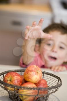 Royalty Free Photo of a Boy Reaching for an Apple