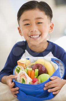 Royalty Free Photo of a Boy With a Lunchbox