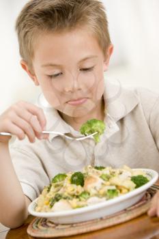 Royalty Free Photo of a Boy Eating Pasta and Broccoli