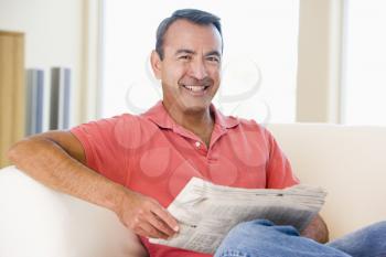 Royalty Free Photo of a Man Reading a Newspaper on the Couch