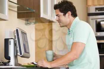 Royalty Free Photo of a Man With a Coffee at the Computer