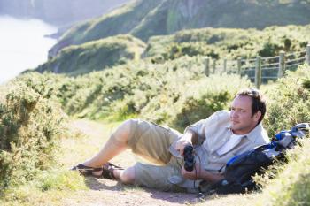 Royalty Free Photo of a Man Relaxing on a Cliff
