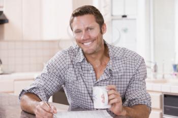 Royalty Free Photo of a Man Reading a Newspaper and Holding a Coffee
