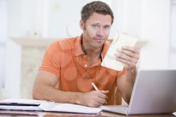 Royalty Free Photo of a Man at a Laptop Doing Paperwork