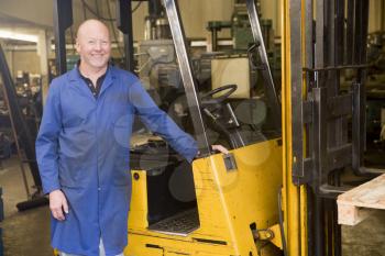 Royalty Free Photo of a Man Beside a Forklift