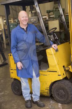 Royalty Free Photo of a Man Beside a Forklift
