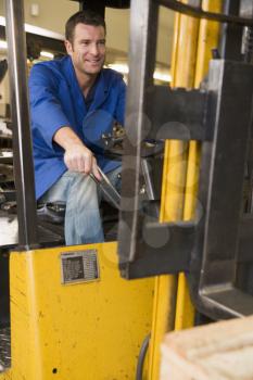 Royalty Free Photo of a Man Driving a Forklift